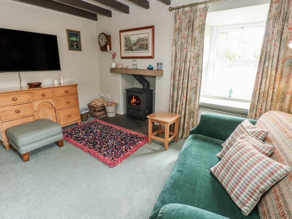 A living room with a television and a fireplace at Bill's Place in Bainbridge near Hawes