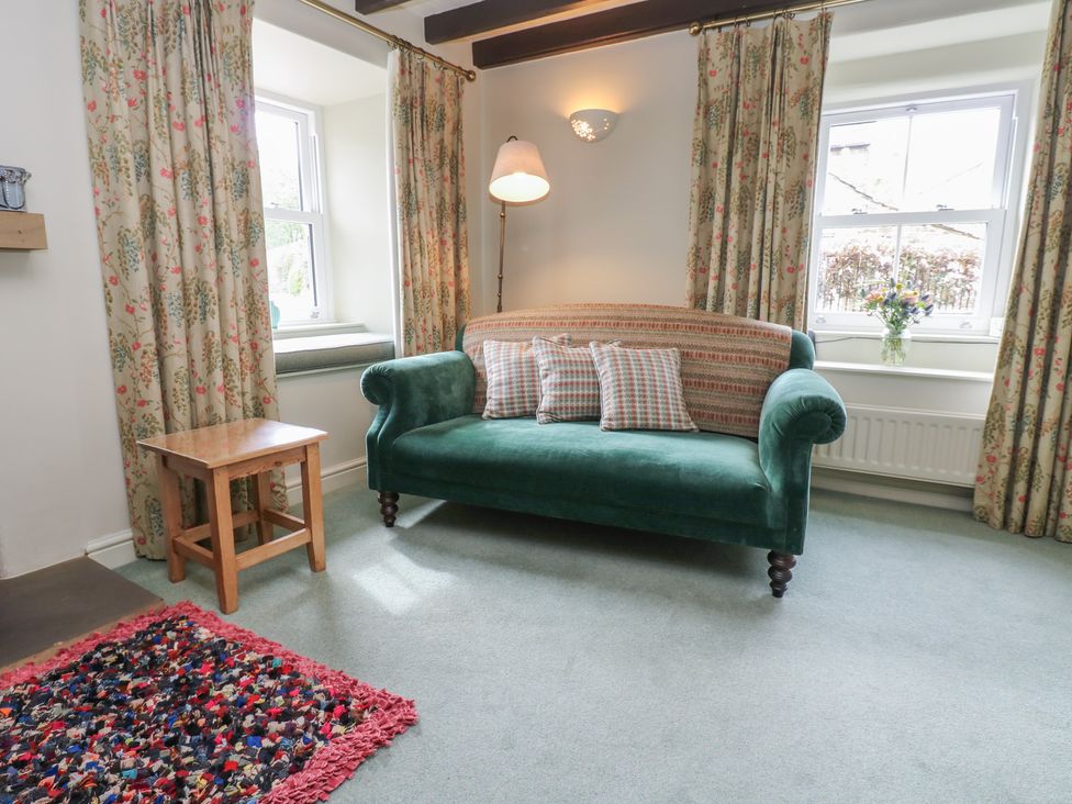 A living room with a green sofa and table at Bill's Place Bainbridge near Hawes