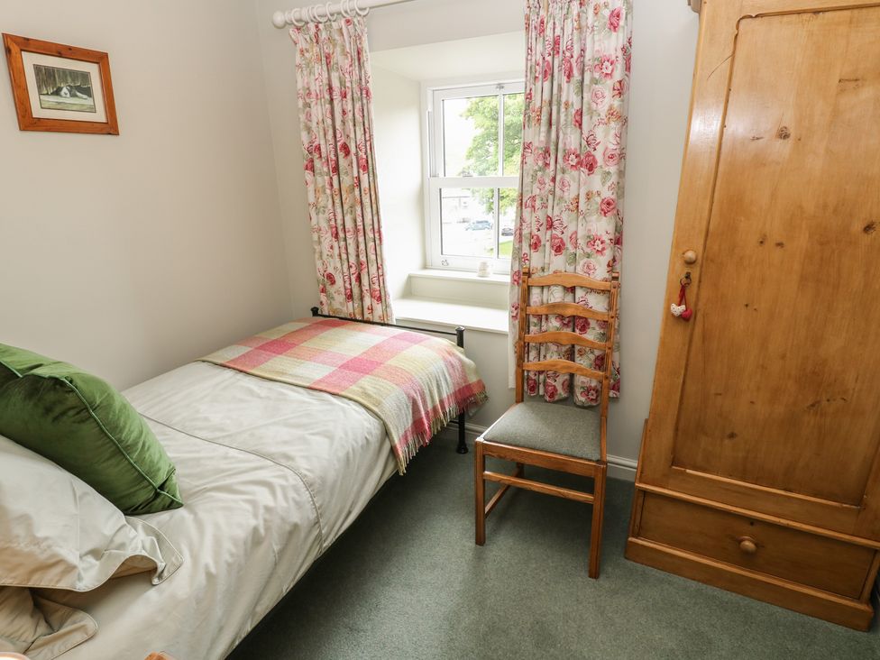 A bedroom with a single bed and a chair at Bill's Place in Bainbridge near Hawes