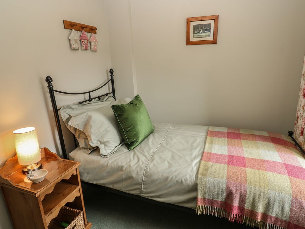 A bedroom with a bed and nightstand at Bill's Place in Bainbridge near Hawes