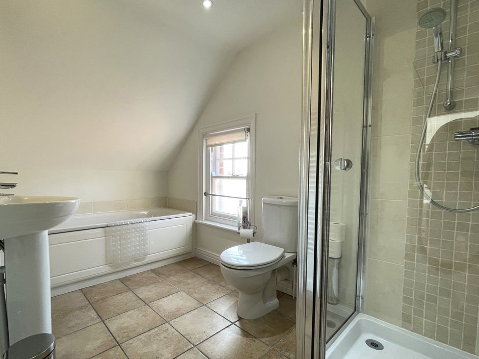 A bathroom with a bathtub, toilet, sink, and shower at Sterling House in Robin Hood's Bay