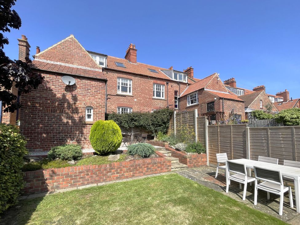 A garden with a table and chairs at Sterling House in Robin Hood's Bay