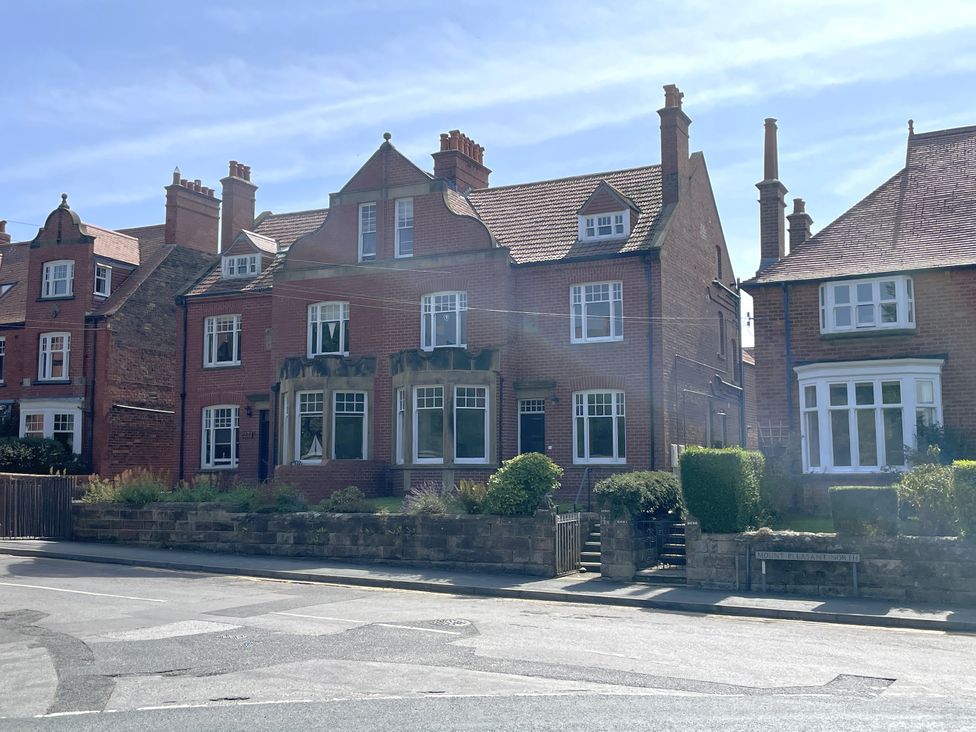 A brick house with a garden and multiple windows at Sterling House in Robin Hood's Bay