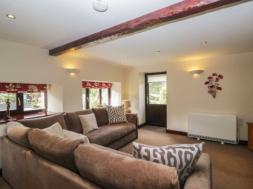 A living room with a sofa and a door at Woodside Barn Pennington near Ulverston