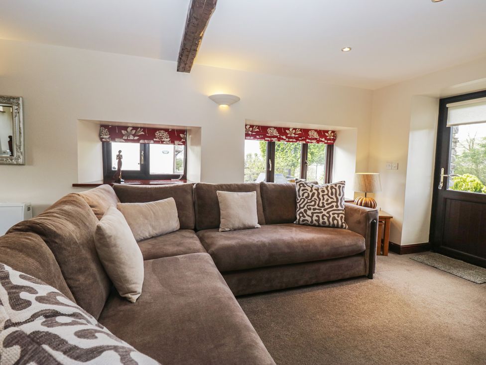A living room with a sofa and windows at Woodside Barn Pennington near Ulverston