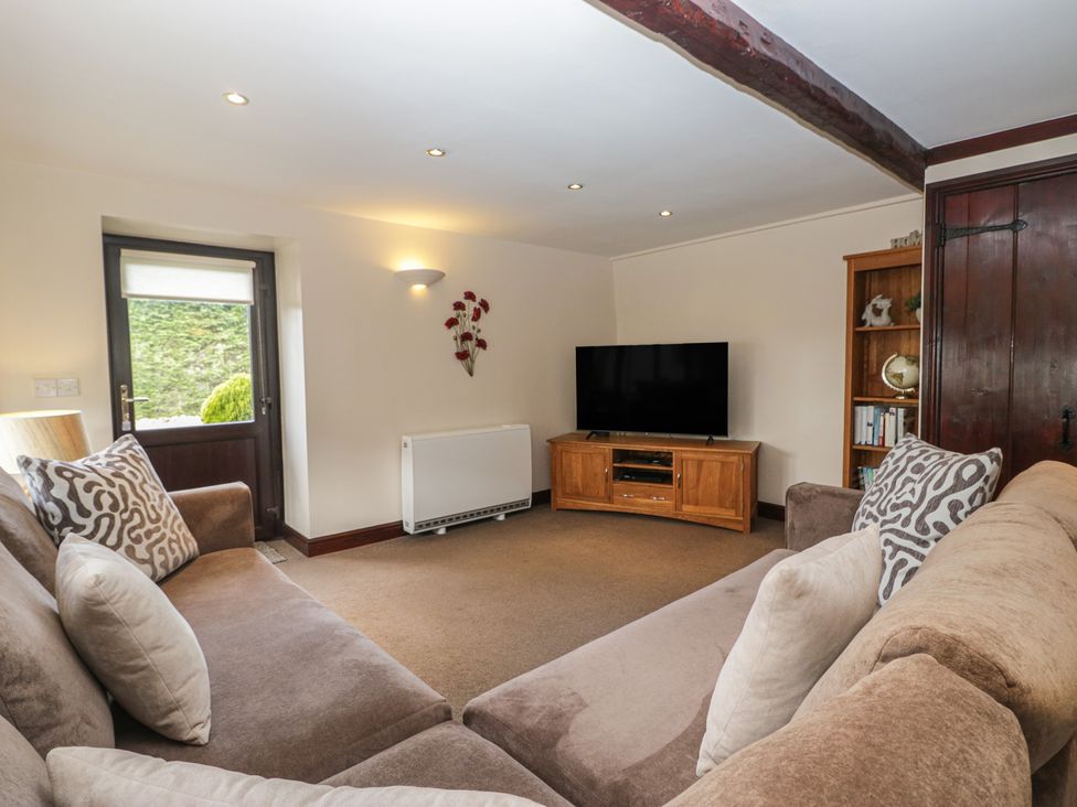 A living room with a sofa and television at Woodside Barn Pennington near Ulverston