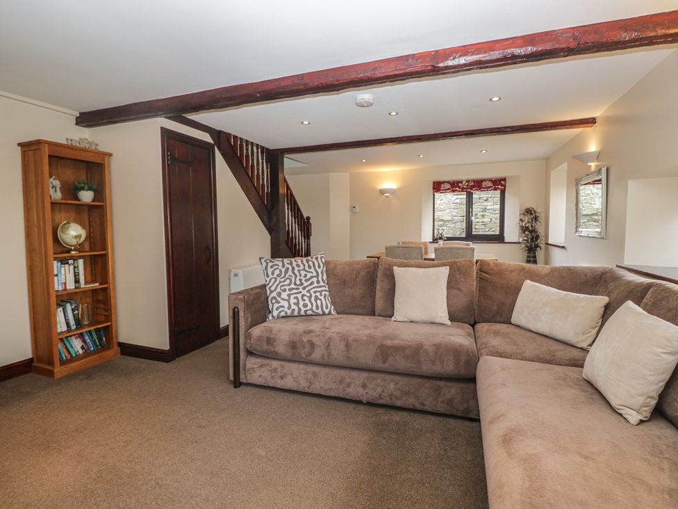 A living room with a sofa and bookshelf at Woodside Barn Pennington near Ulverston