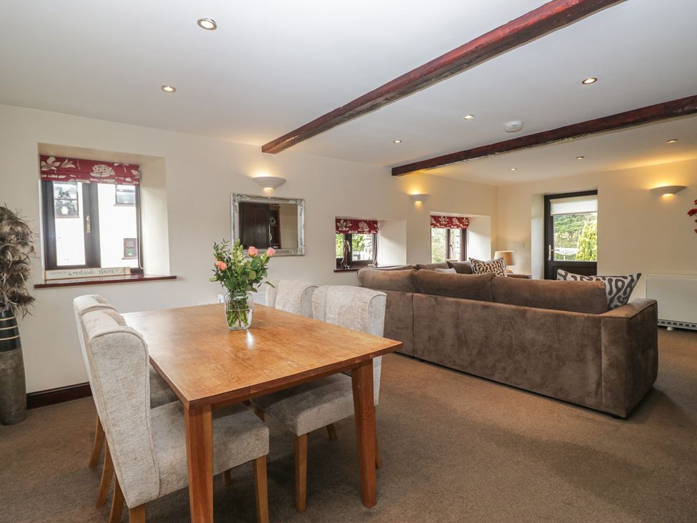 A living room with a dining table and sofa at Woodside Barn Pennington near Ulverston