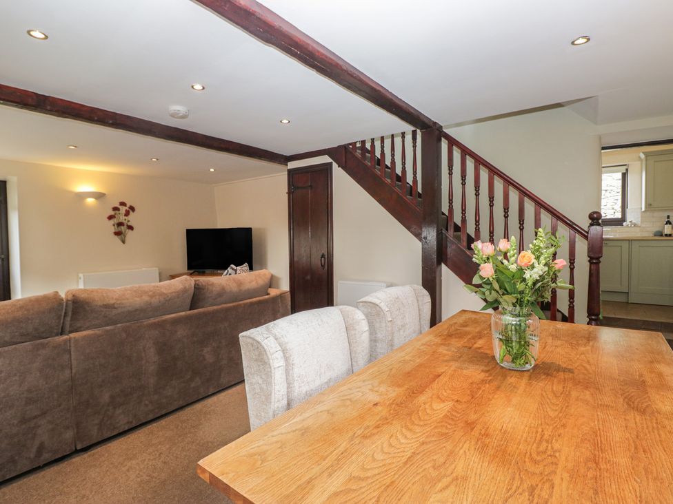 A living room with a sofa and dining table at Woodside Barn Pennington near Ulverston
