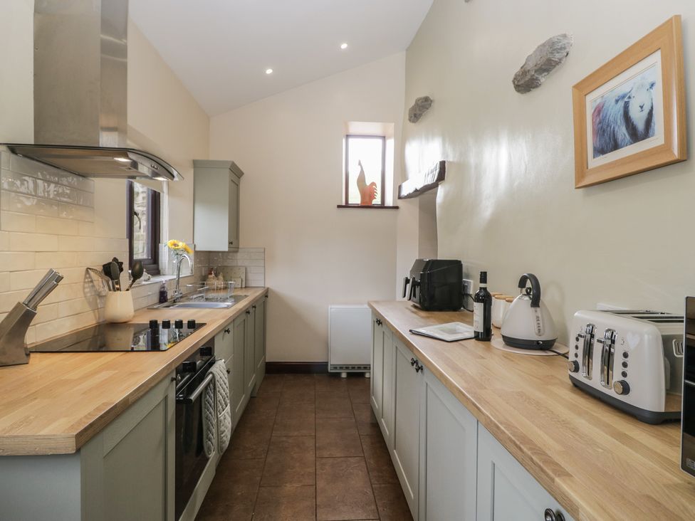 A kitchen with cabinets and appliances at Woodside Barn Pennington near Ulverston