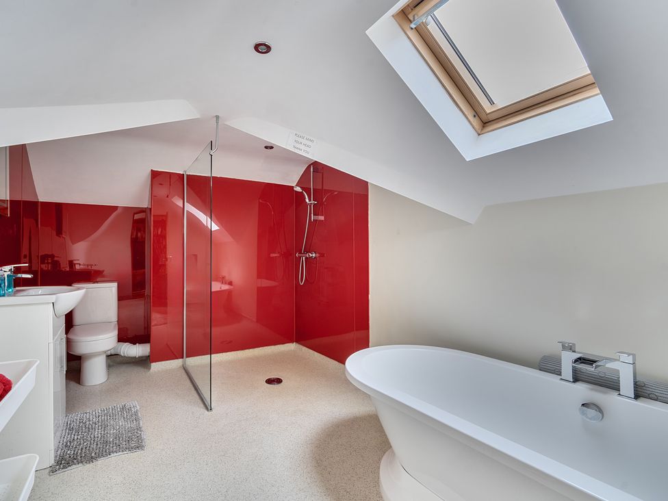 A bathroom with a shower, bathtub, toilet, and sink at Chapel Green in Polgooth
