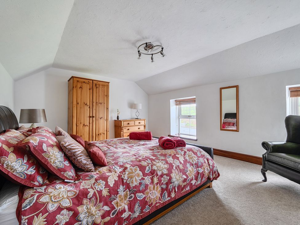 A bedroom with a bed and wardrobe at Chapel Green in Polgooth