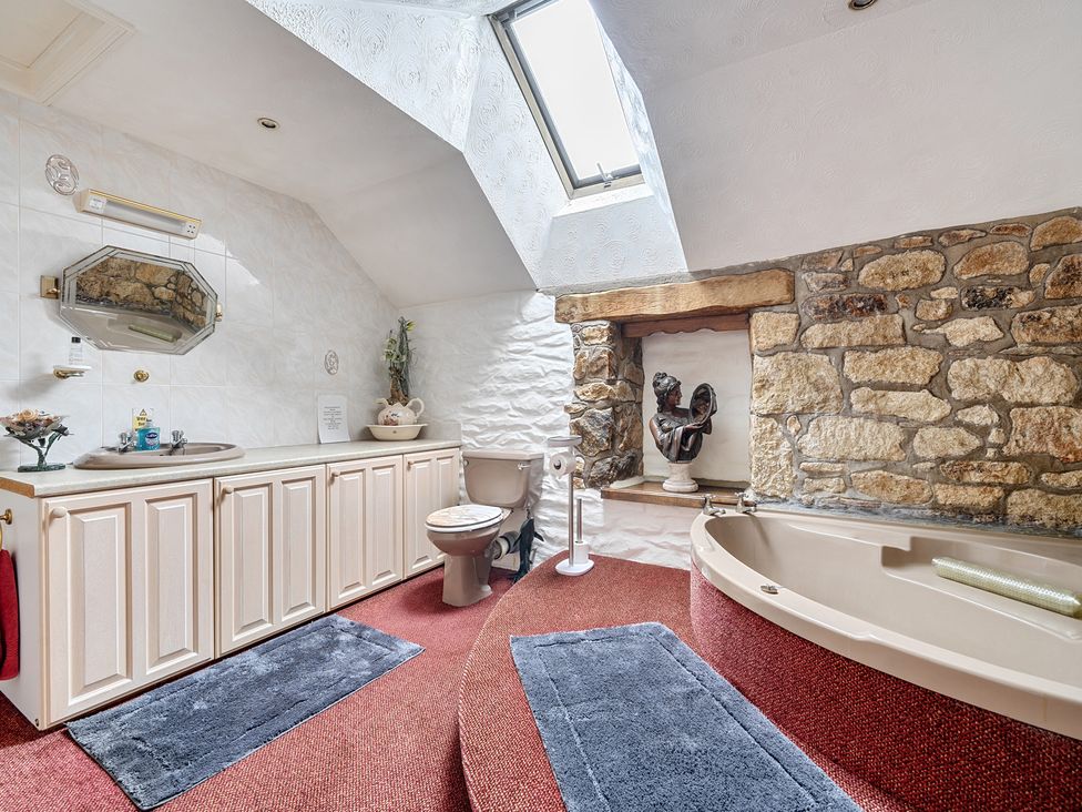 A bathroom with a bath tub and sink at Chapel Green, Polgooth