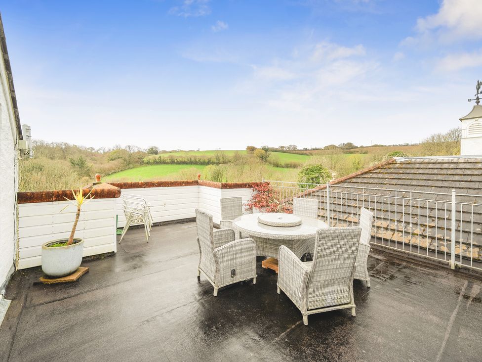 An outdoor area with a table and chairs at Chapel Green in Polgooth