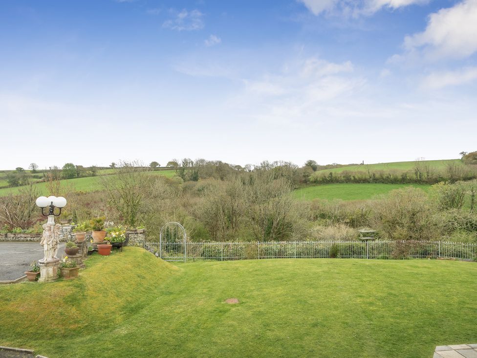 A garden with a lamp post and potted plants at Chapel Green in Polgooth