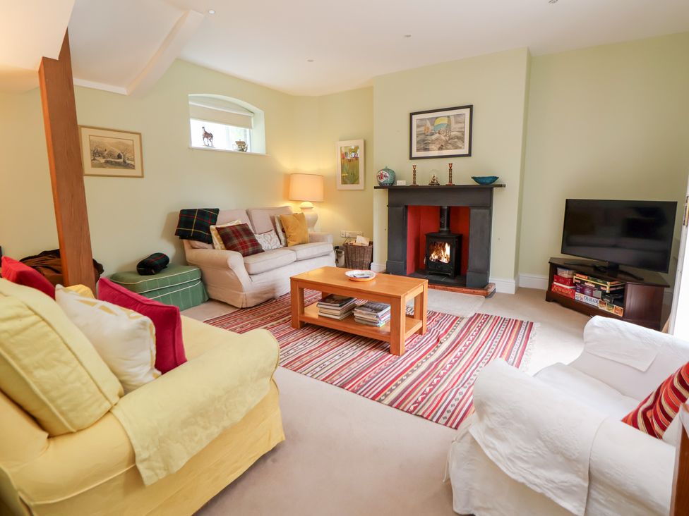 A living room with a fireplace and seating at Bryn Howell Stables Trevor near Llangollen