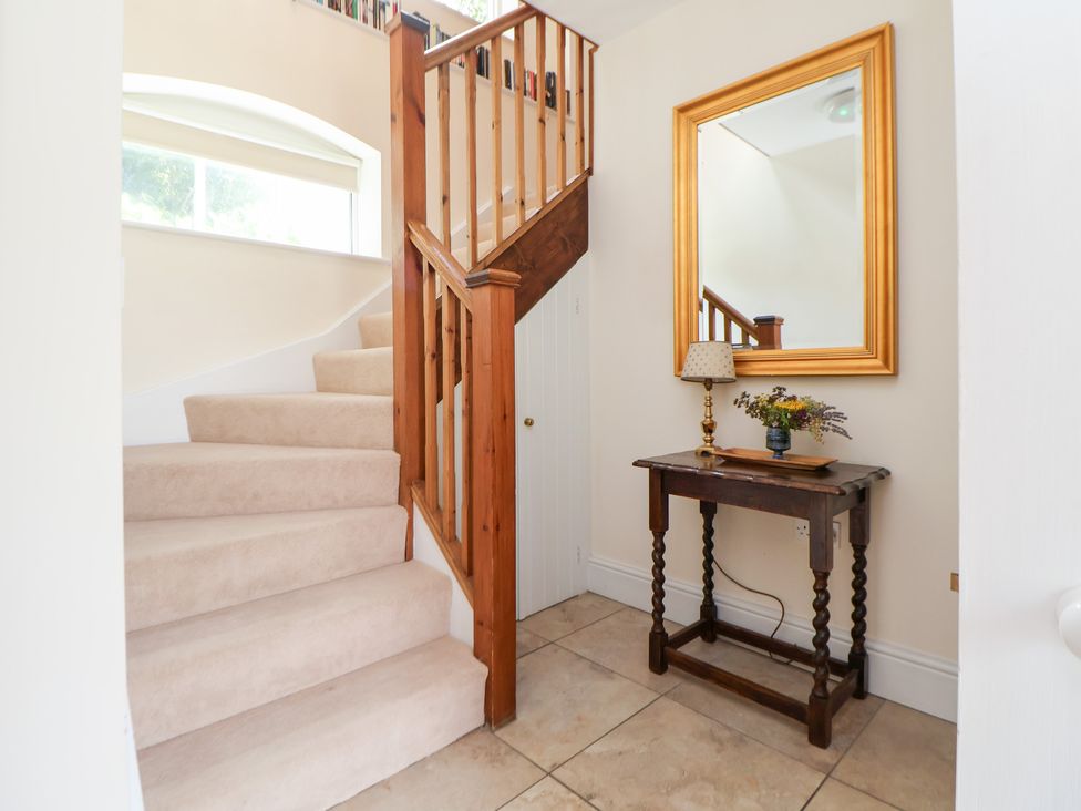A hallway with stairs and a console table at Bryn Howell Stables Trevor near Llangollen