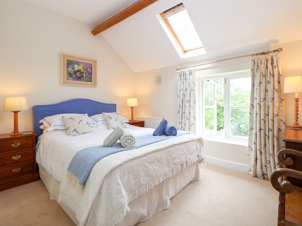 A bedroom with a bed, bedside tables and a window at Bryn Howell Stables Trevor near Llangollen