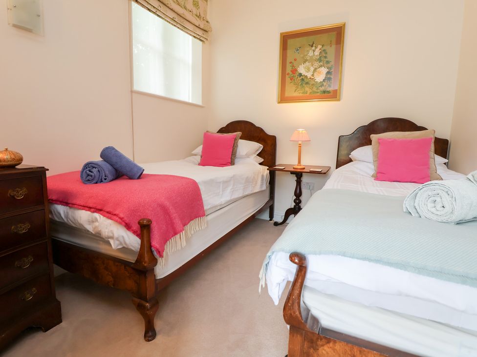 A bedroom with two single beds and a bedside table at Bryn Howell Stables near Trevor near Llangollen