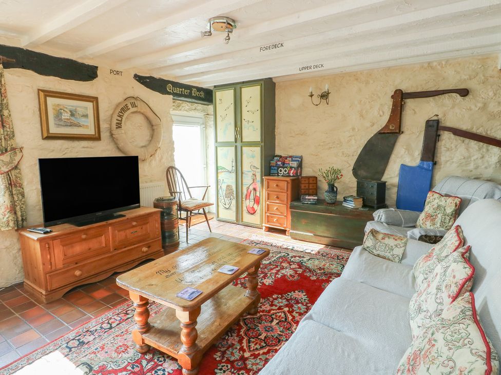 A living room with a television and coffee table at Crow's Nest Cottage in Tynygongl near Benllech