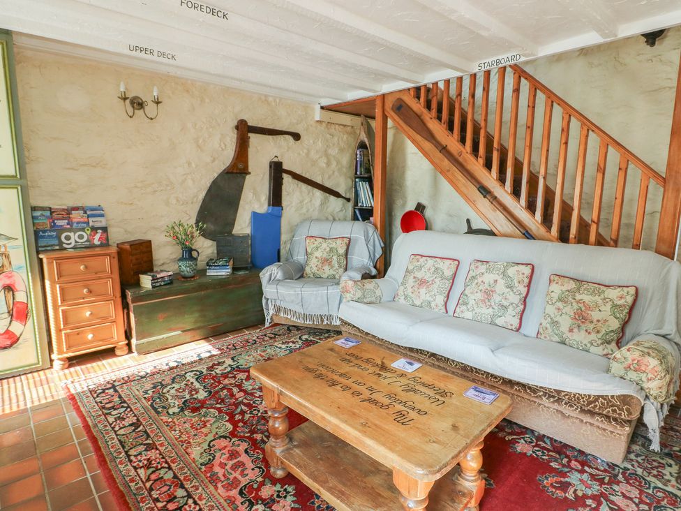 A living room with a sofa and coffee table at Crow's Nest Cottage in Tynygongl near Benllech
