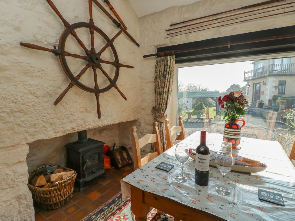 A dining room with a table set for a meal at Crow's Nest Cottage in Tynygongl near Benllech