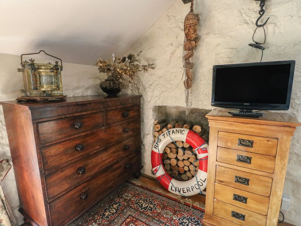 A bedroom with chest of drawers and television at Crow's Nest Cottage Tynygongl near Benllech