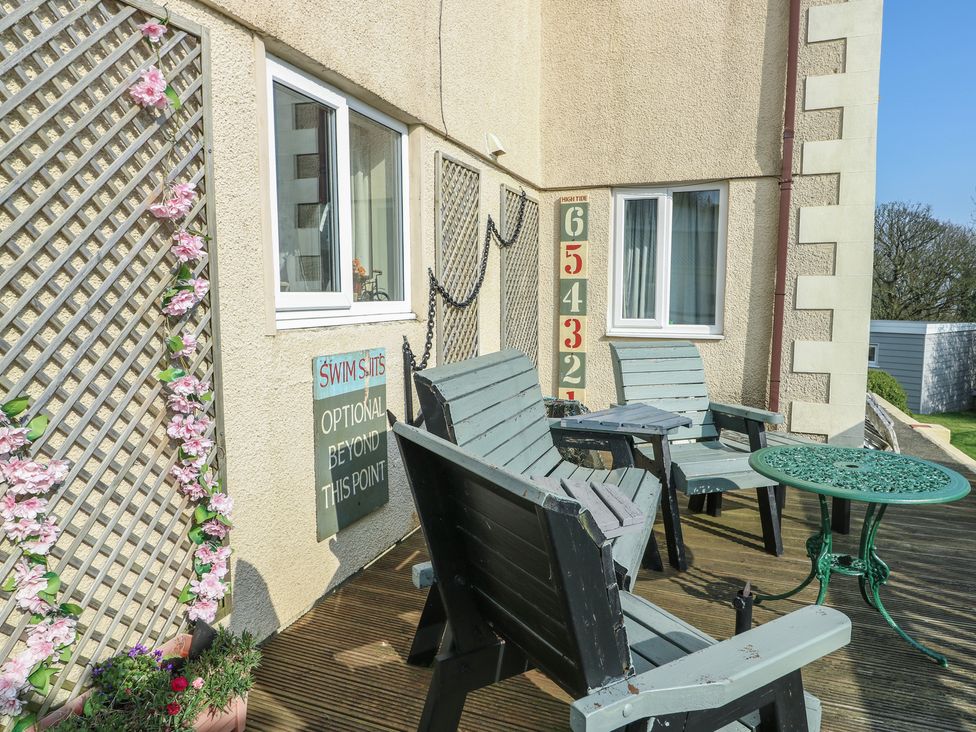 An outdoor seating area with chairs and a table at Crow's Nest Cottage Tynygongl near Benllech