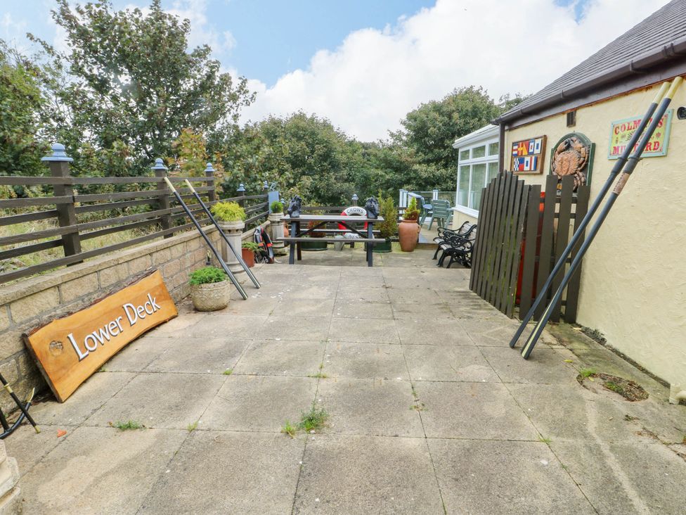An outdoor area with a table and chairs at Crow's Nest Cottage in Tynygongl near Benllech