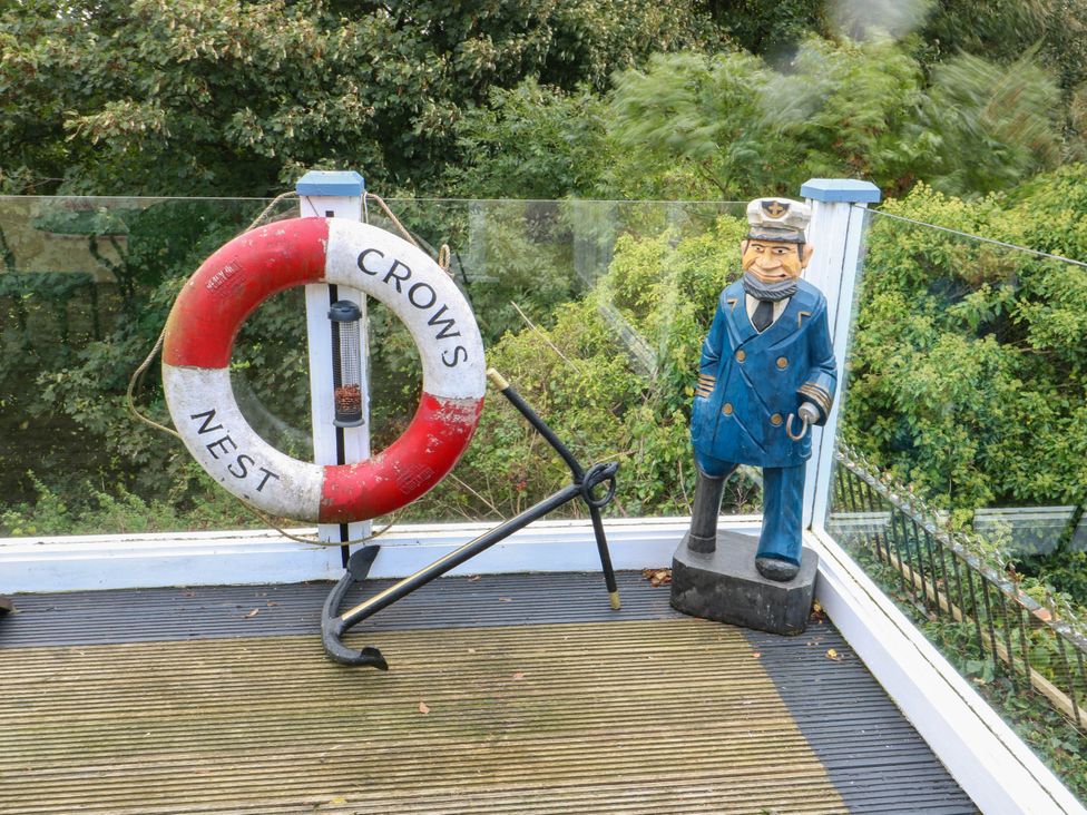An outdoor space with a lifebuoy and a nautical figurine at Crow's Nest Cottage Tynygongl near Benllech