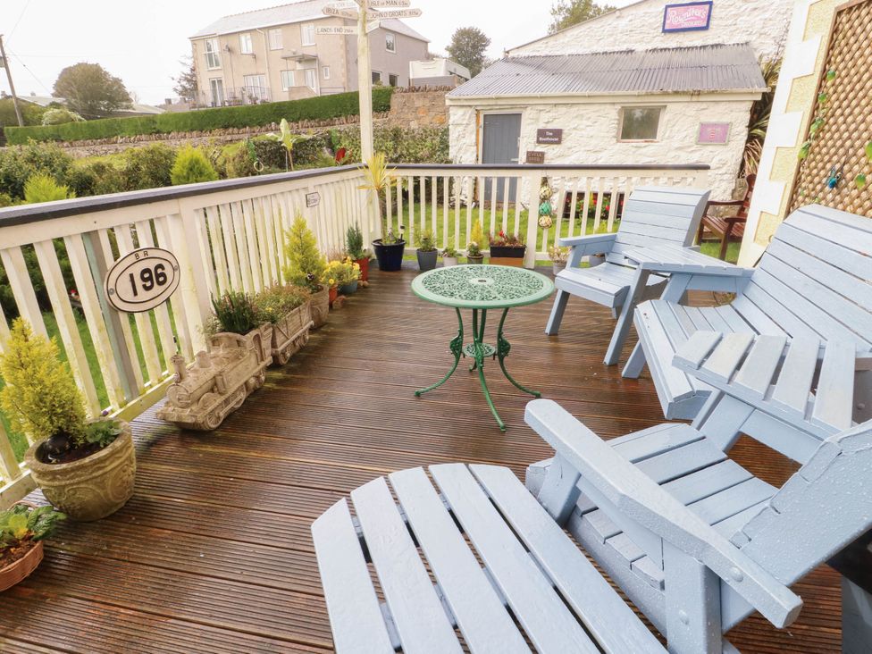 An outdoor area with chairs and a table at Crow's Nest Cottage Tynygongl near Benllech