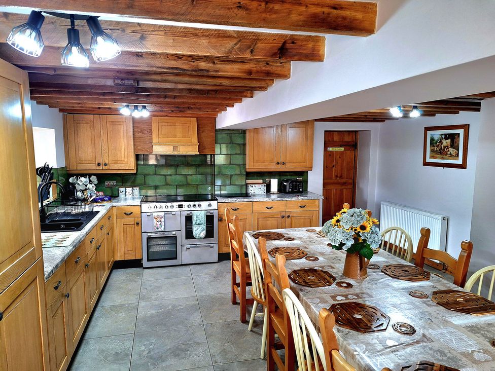 A kitchen with cabinets, dining table, and oven at Boundcliffe Farm Allerston near Pickering