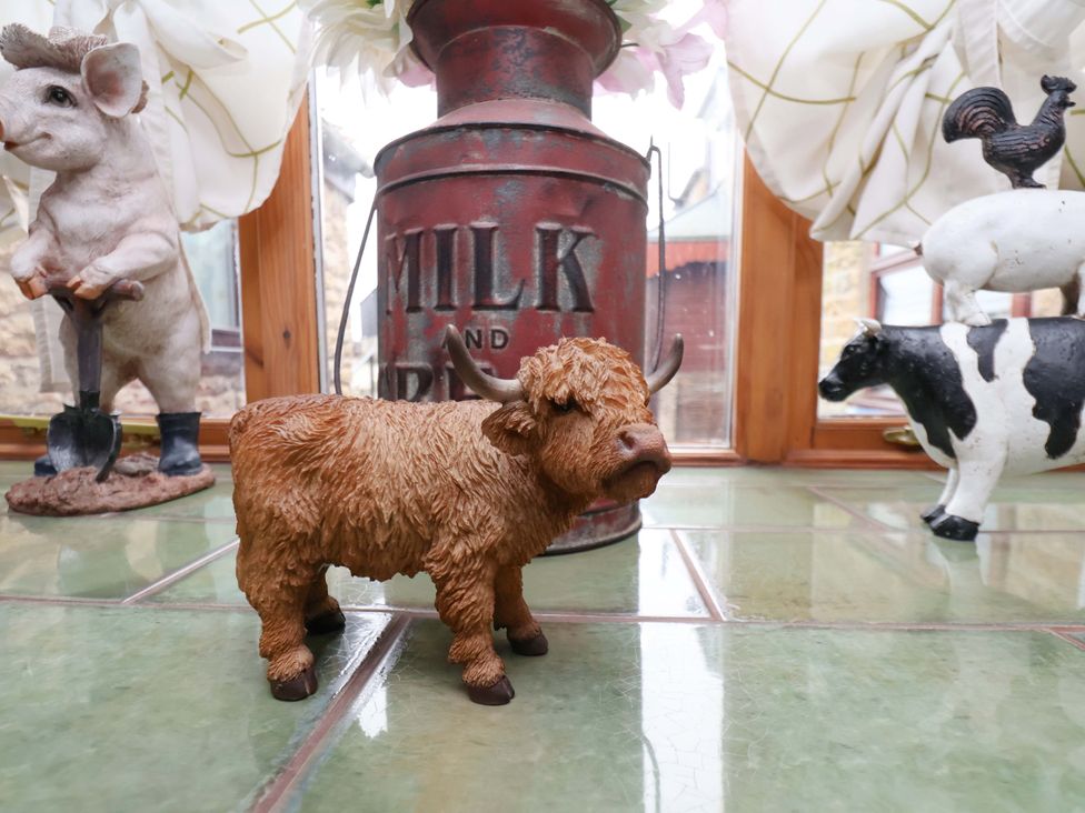 A collection of animal figurines and a milk can in a conservatory at Boundcliffe Farm Allerston near Pickering