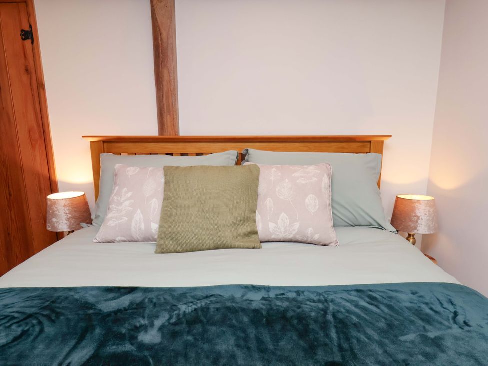 A bed with pillows and lamps in a bedroom at Boundcliffe Farm Allerston near Pickering
