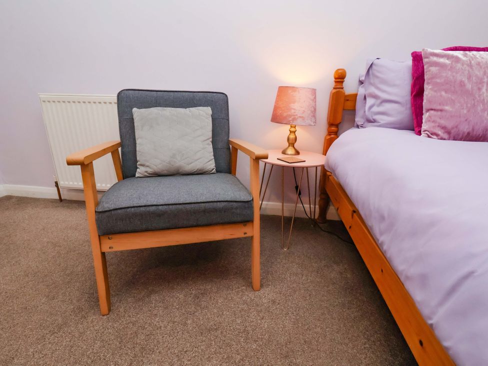 A bedroom featuring an armchair and bedside table at Boundcliffe Farm in Allerston near Pickering