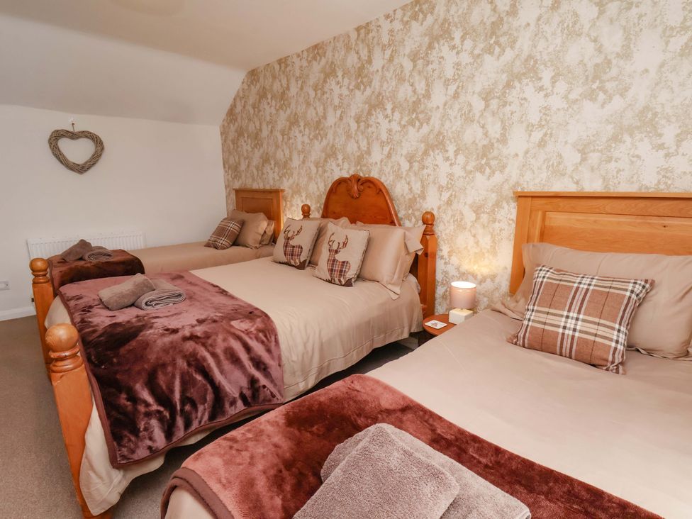 A bedroom with multiple beds and decorative pillows at Boundcliffe Farm in Allerston near Pickering