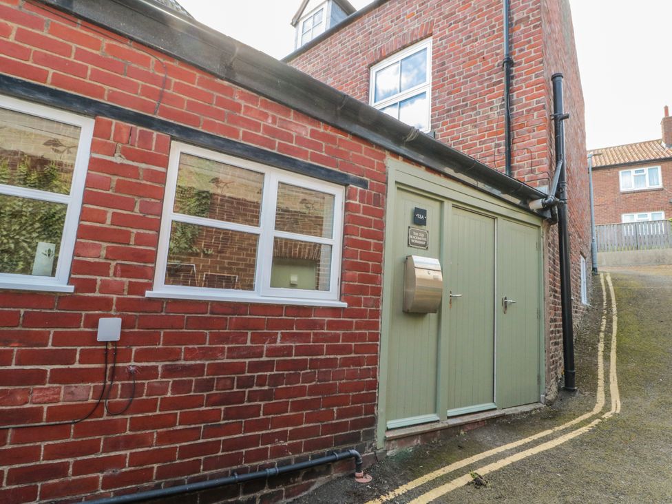 An outdoor view of a brick building with a door and windows at The Old Blacksmith's Workshop in Whitby