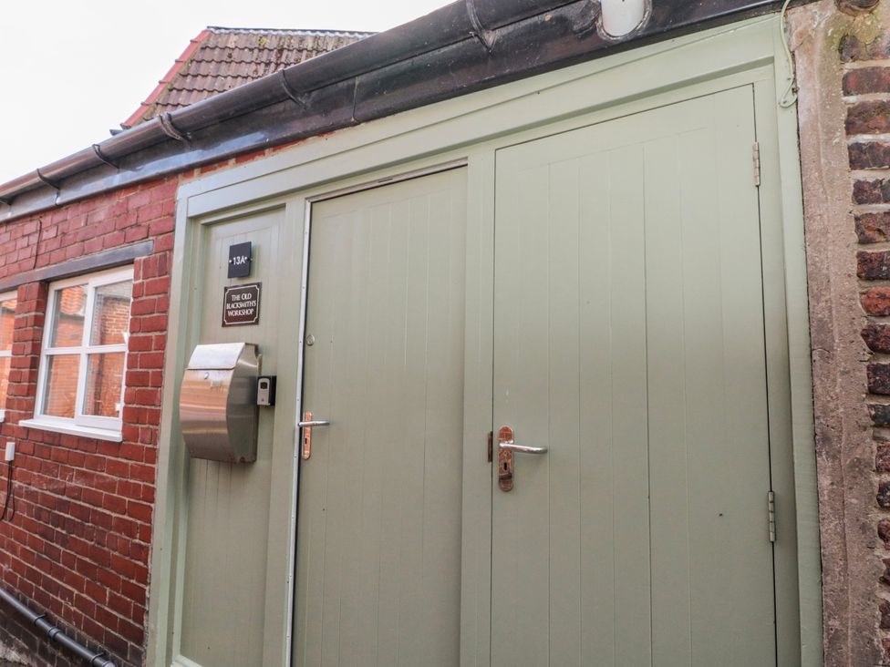 An entrance with a green door and mailbox at The Old Blacksmith's Workshop Whitby
