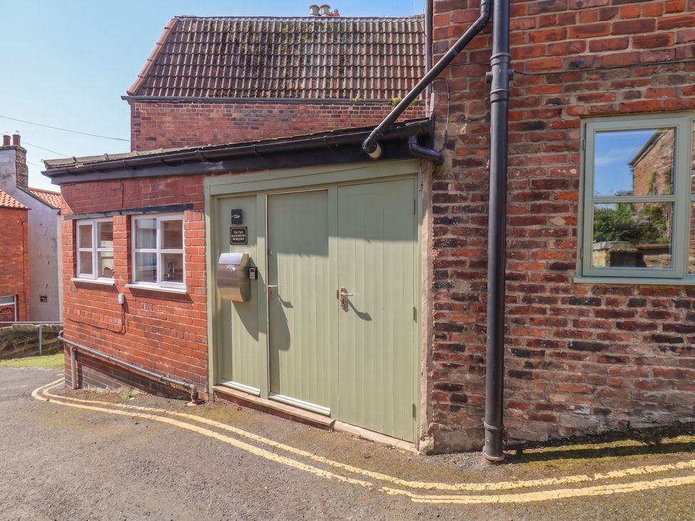 An exterior view showing a green door and windows at The Old Blacksmith's Workshop in Whitby