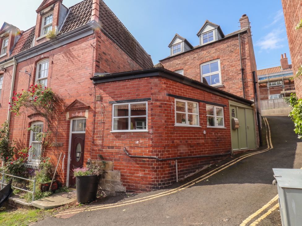 A brick house with a pathway and plants at The Old Blacksmith's Workshop in Whitby