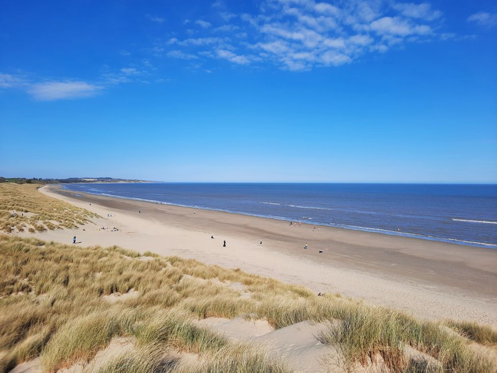 A beach with sand and people walking along the shore at 19 River Glen, Curracloe, County Wexford