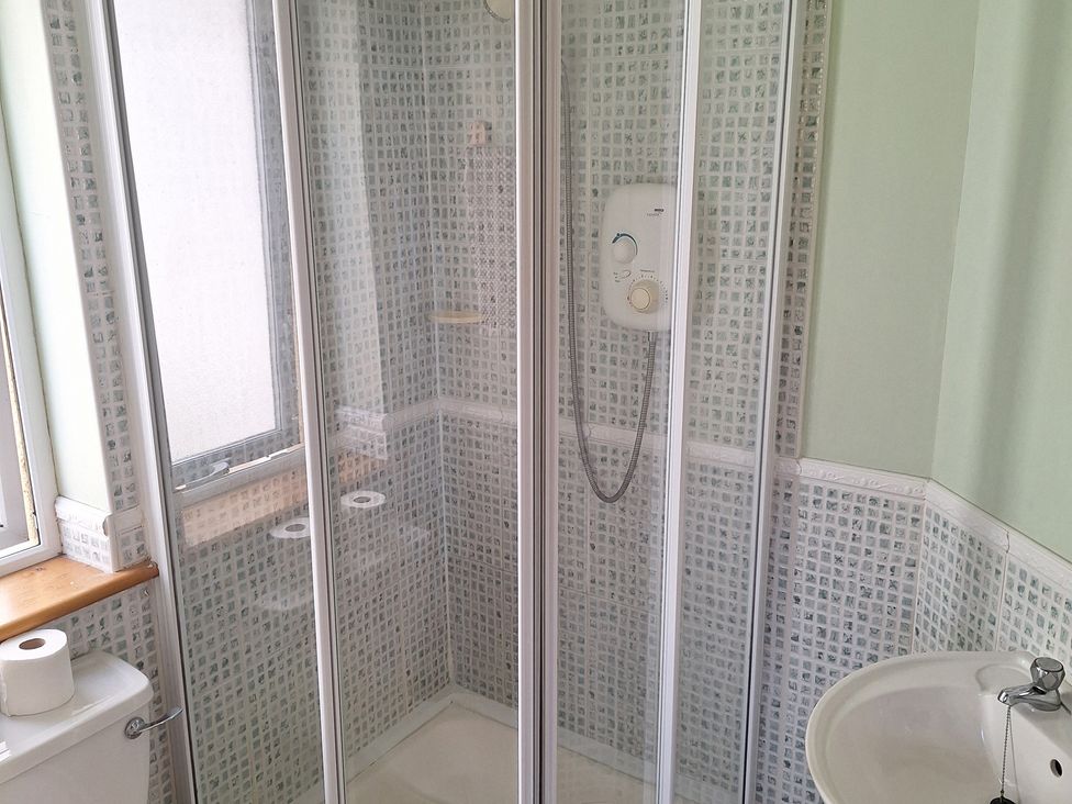 A shower enclosure with a toilet and sink at 19 River Glen in Curracloe, County Wexford