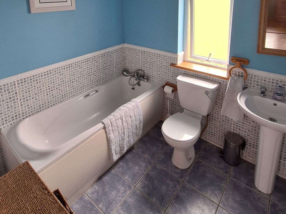 A bathroom with a bathtub, toilet, and sink at 19 River Glen, Curracloe, County Wexford