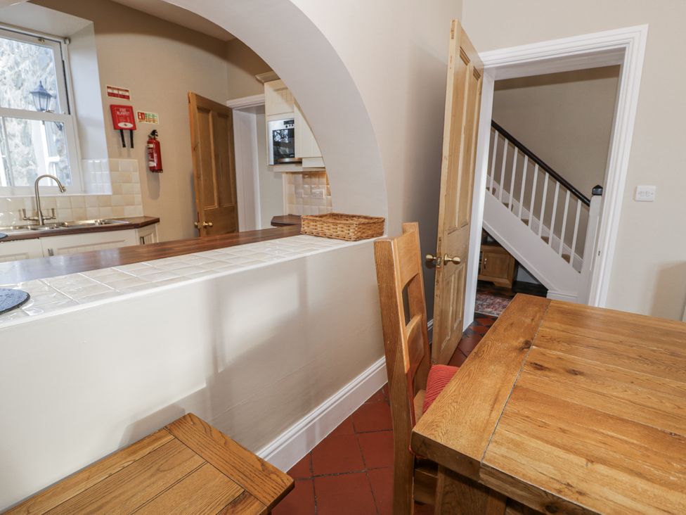 A kitchen with wooden table and chairs at Tyddyn Goronwy in Talybont