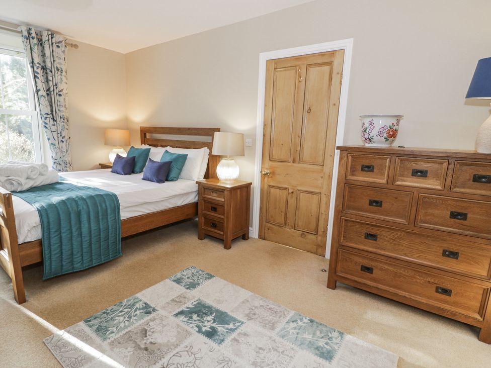 A bedroom with a bed and dresser at Tyddyn Goronwy in Talybont