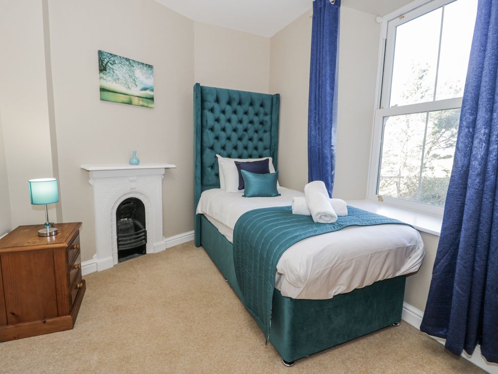 A bedroom with a bed and a bedside table at Tyddyn Goronwy in Talybont