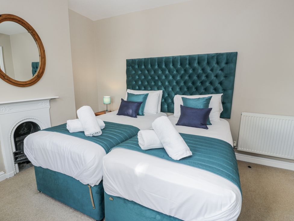 A bedroom with two beds and a mirror at Tyddyn Goronwy in Talybont