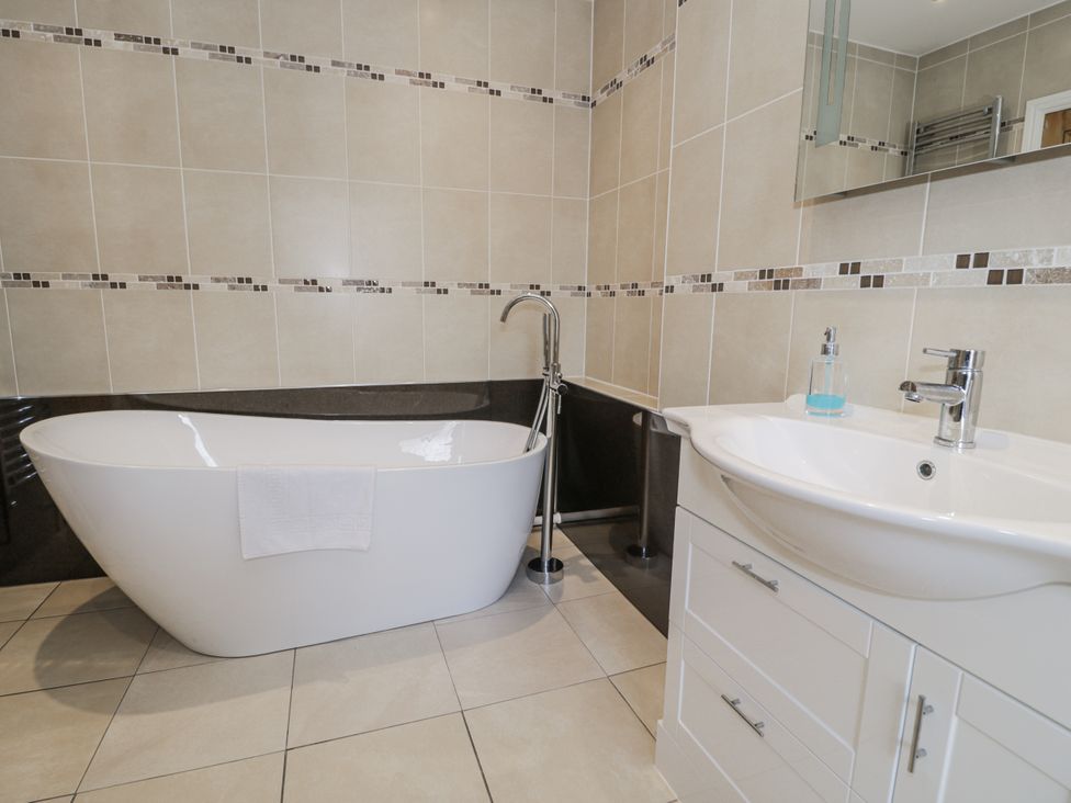 A bathroom with a bathtub and sink at Tyddyn Goronwy in Talybont