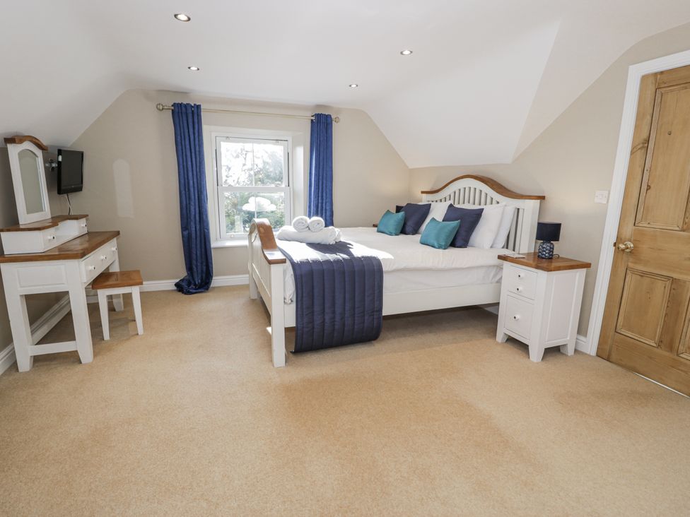 A bedroom with a bed, nightstand, and dresser at Tyddyn Goronwy in Talybont