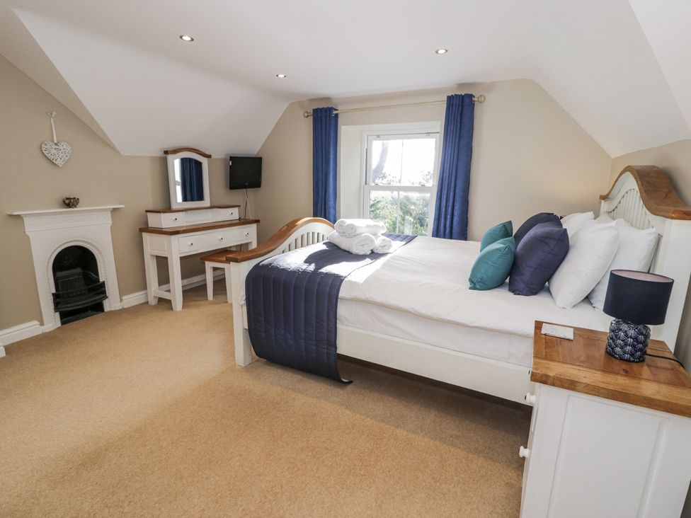 A bedroom with a bed and dresser at Tyddyn Goronwy in Talybont